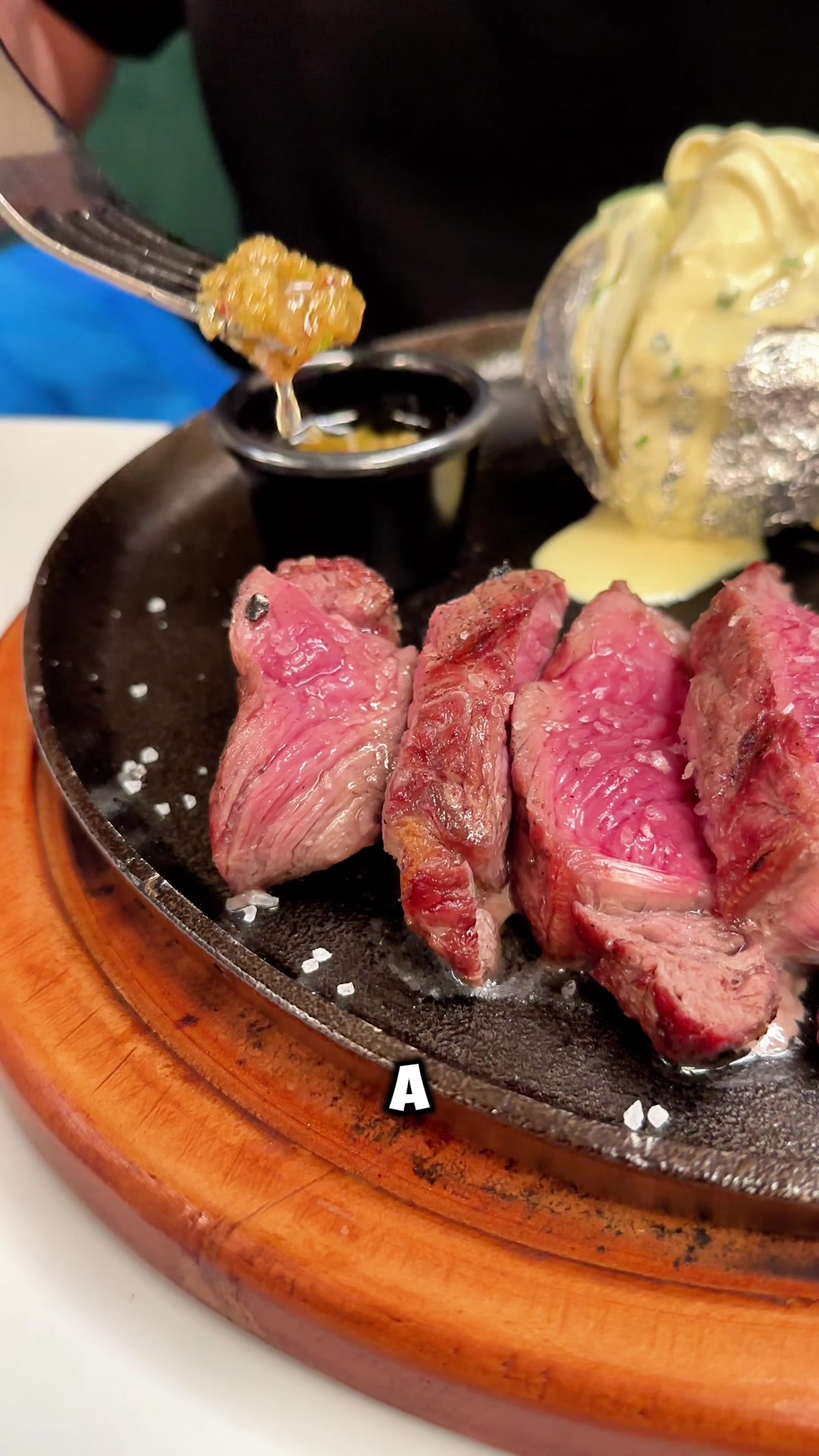 Cortes de carne término medio sobre sartén de hierro y tabla de madera